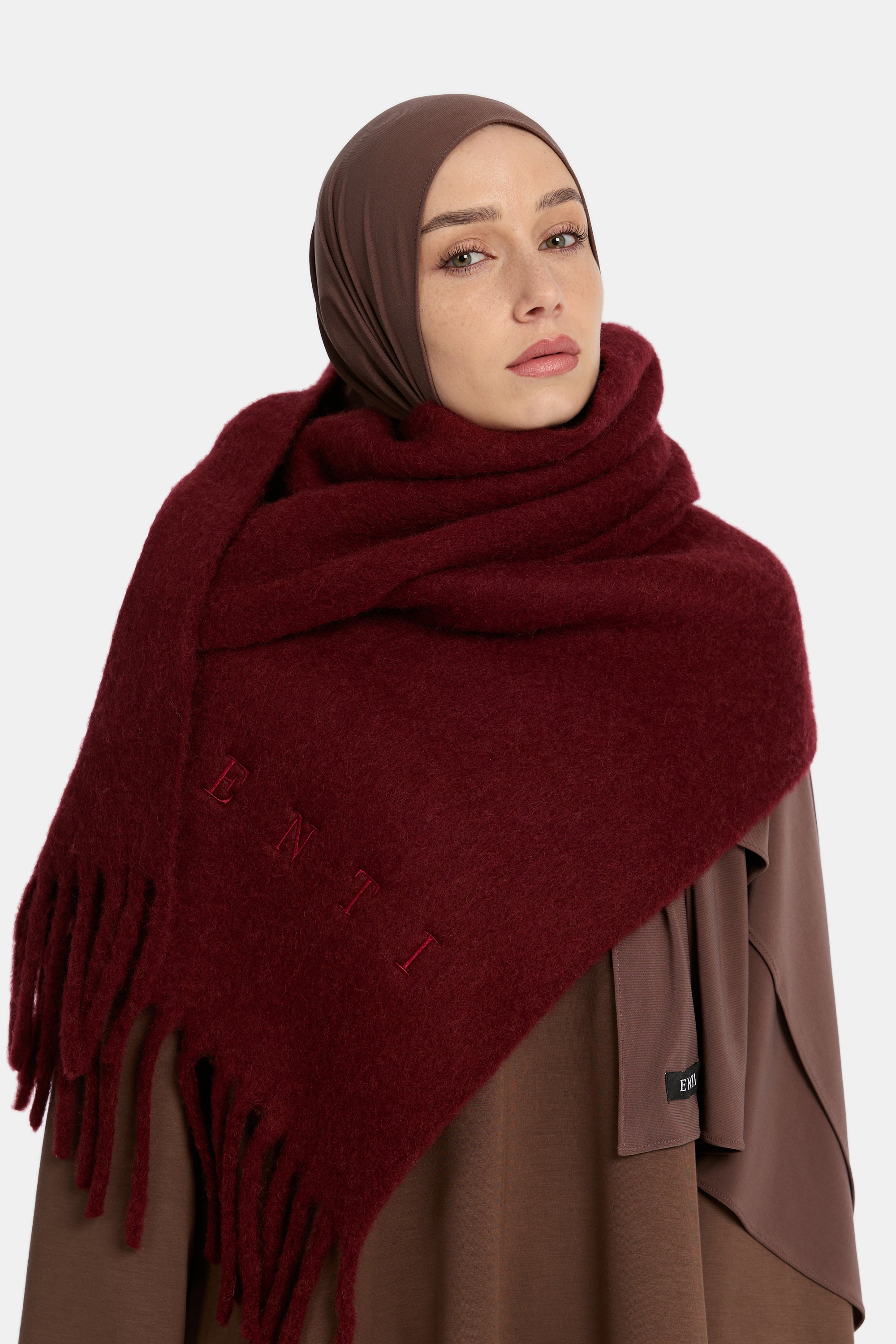 close up van de model die draagt een ENTI wool scarf in de kleur burgundy