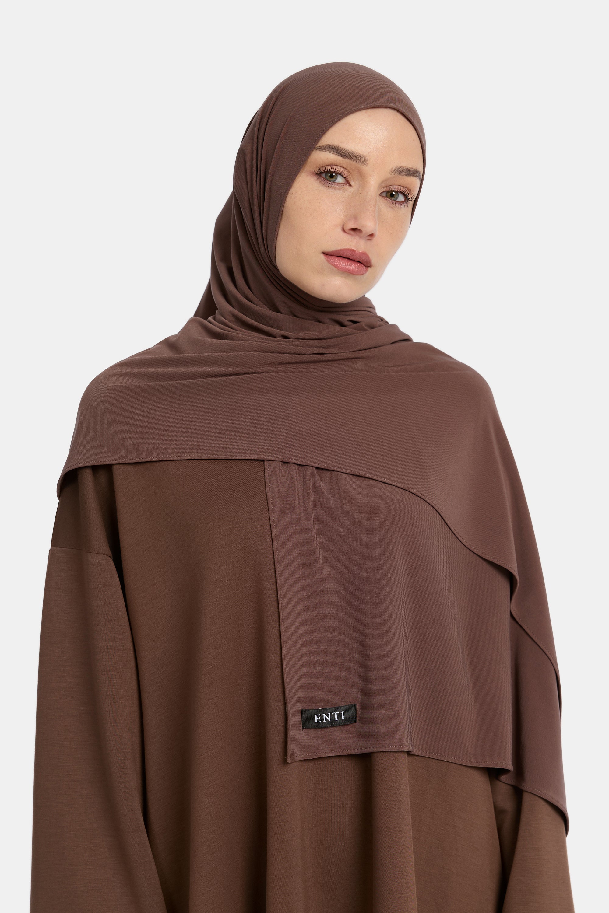 Model draagt de enti premium jersey hoofddoek die ademend is en in de kleur Chai
