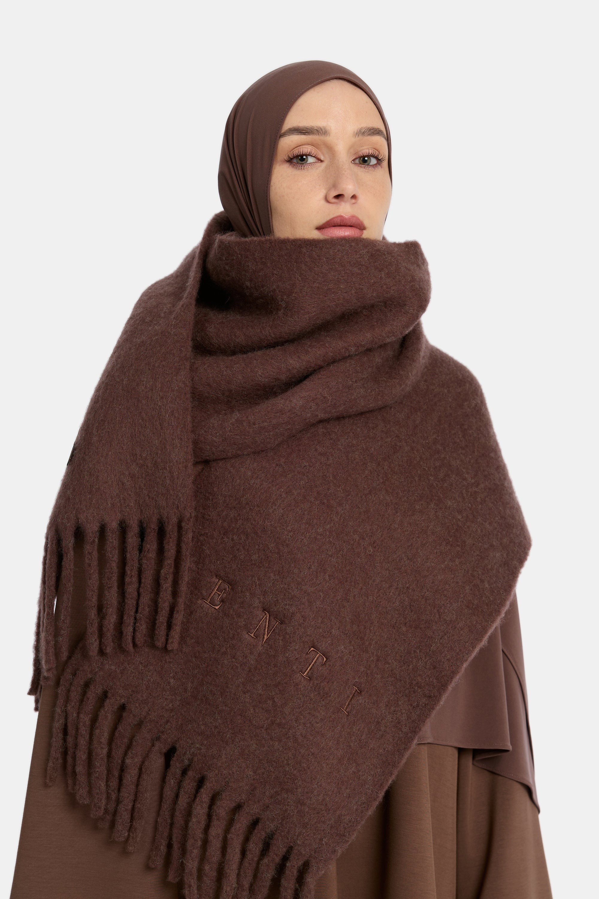 close up van de model die draagt een ENTI wool scarf in de kleur donkerbruin