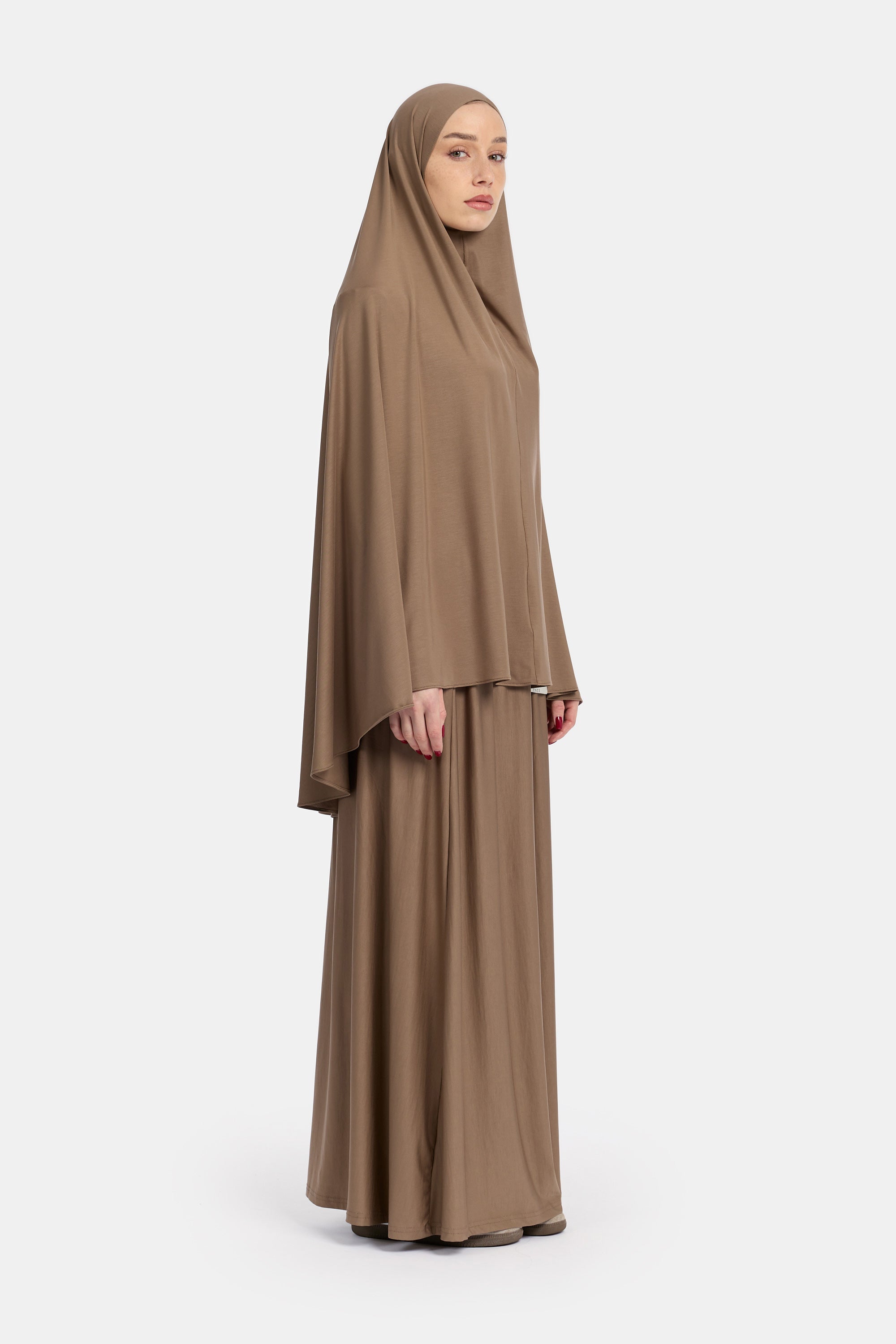 zij aanzicht van Model die draagt de breathable modal khimar en rok van de modest merk ENTI in de kleur bruin