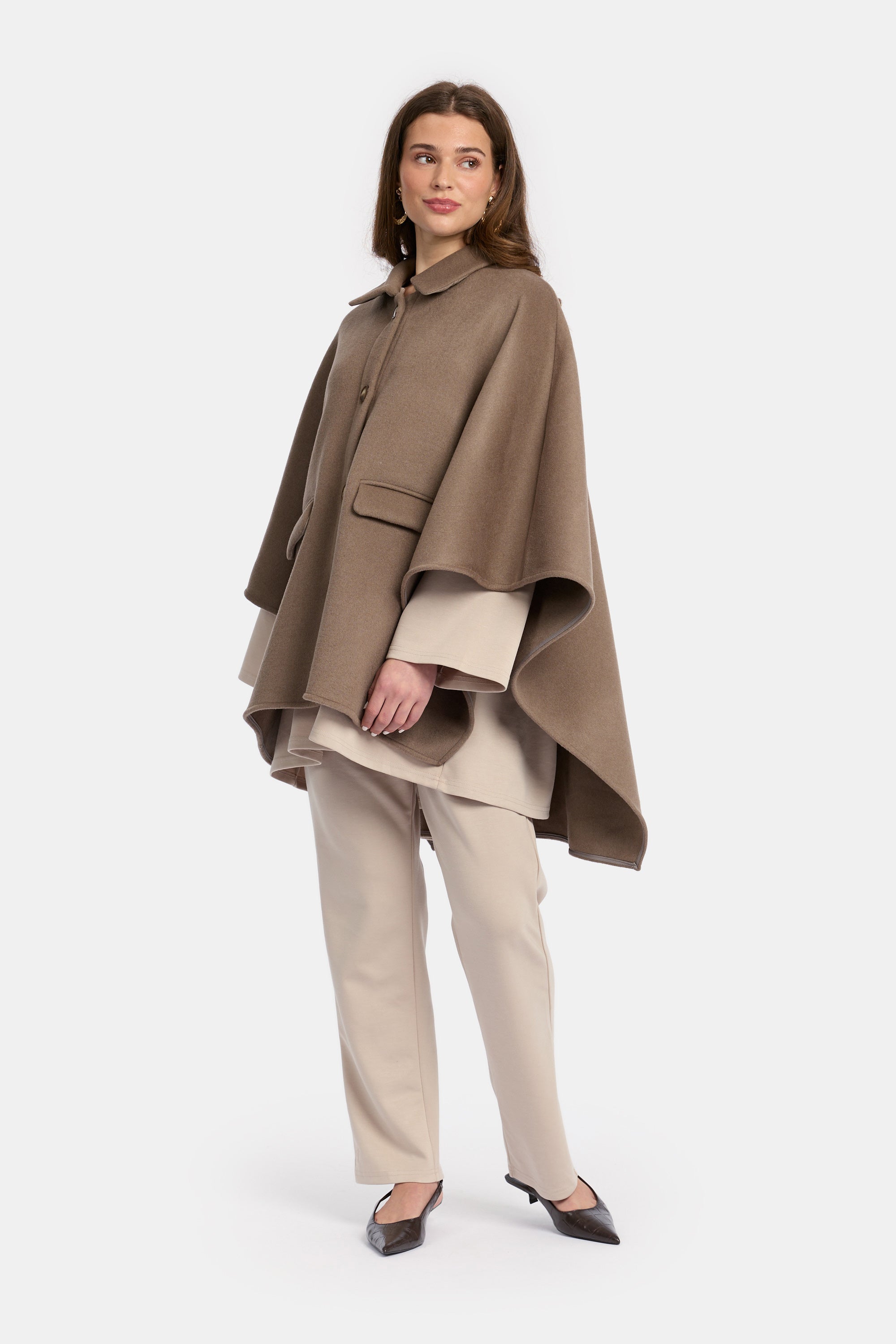 model draagt de wollen poncho van het modest merk enti in de kleur bruin en poseert