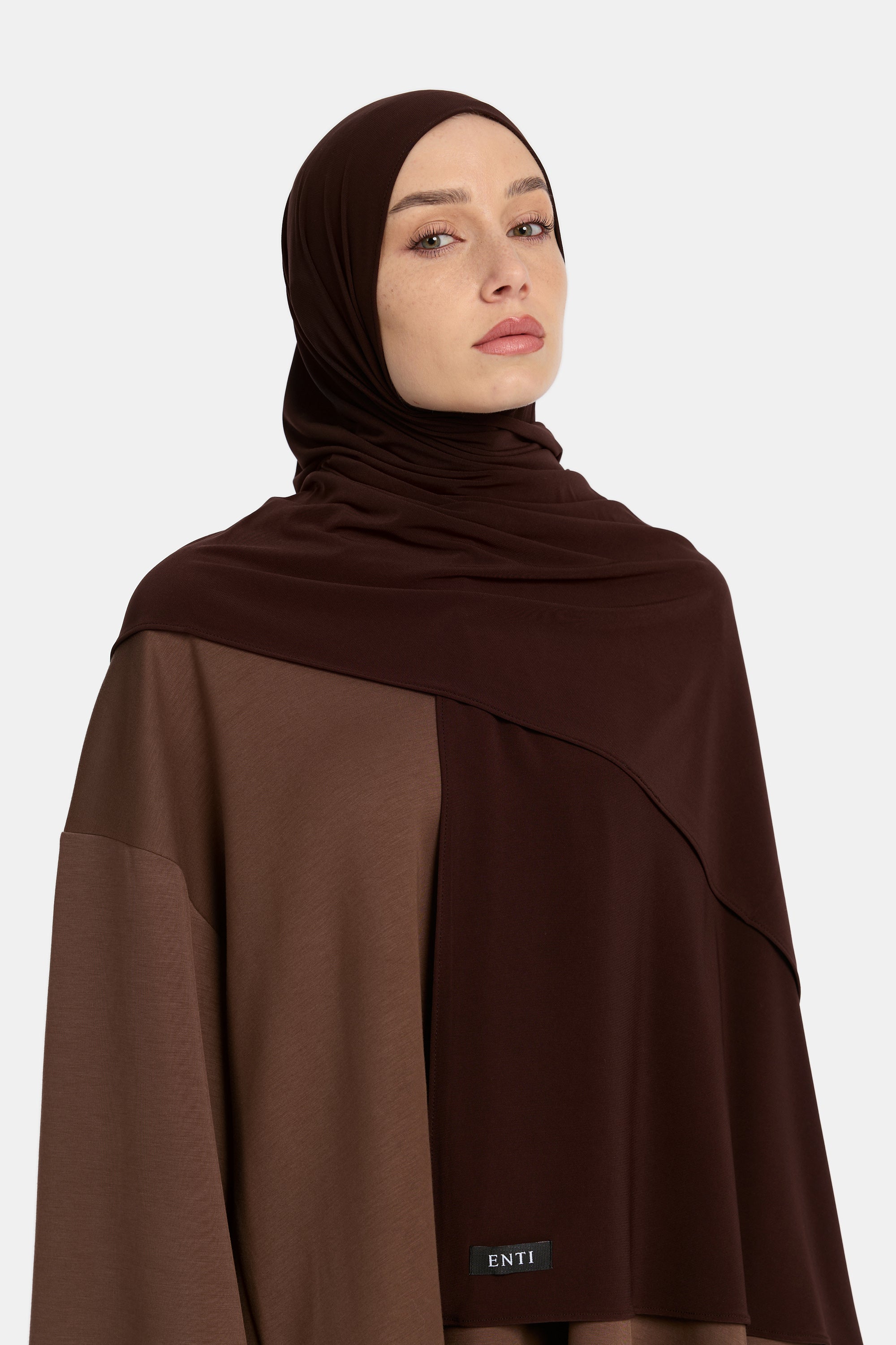 Model draagt de enti premium jersey hoofddoek die ademend is en in de kleur Dark Brown