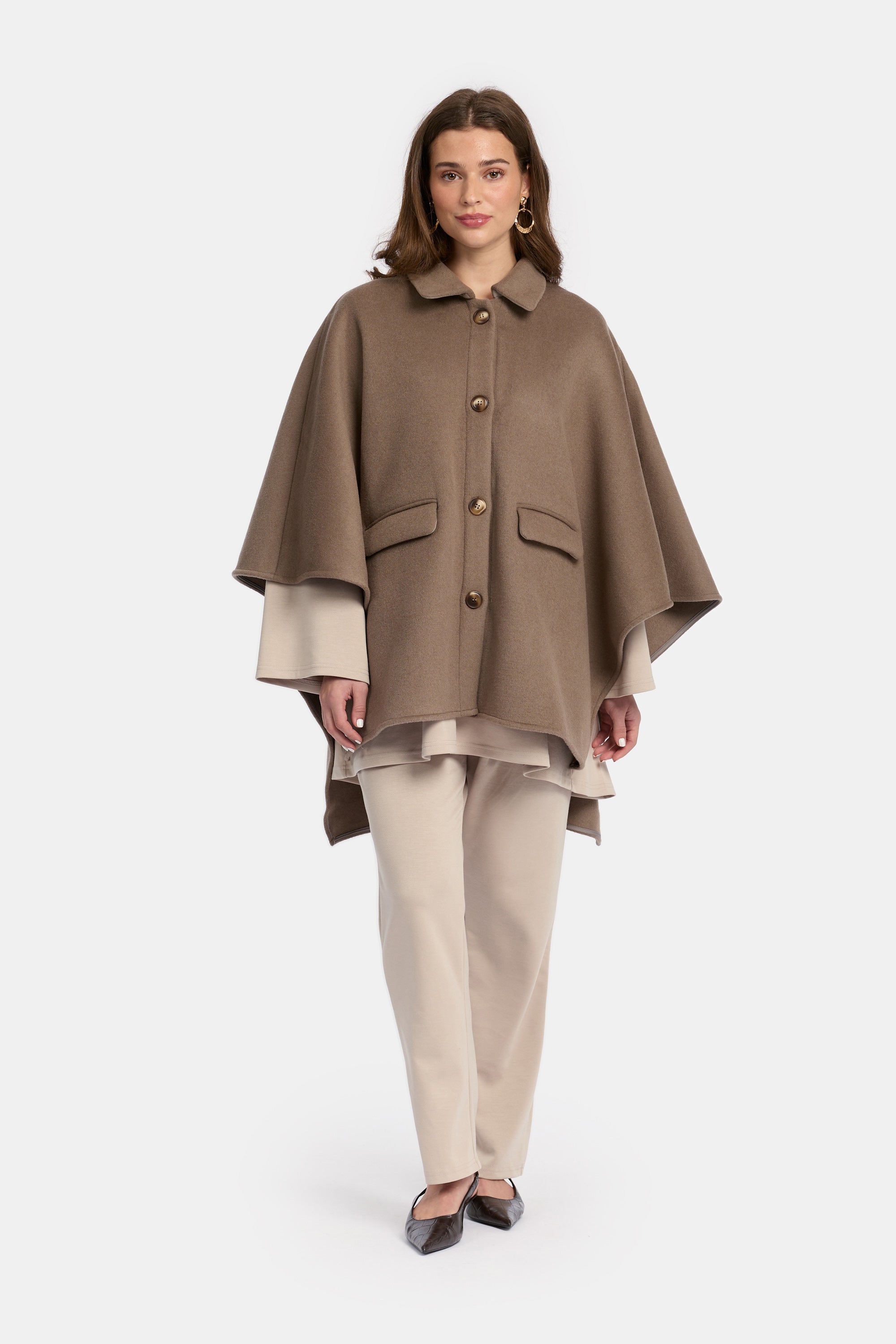 model draagt de wollen poncho van het modest merk enti in de kleur bruin