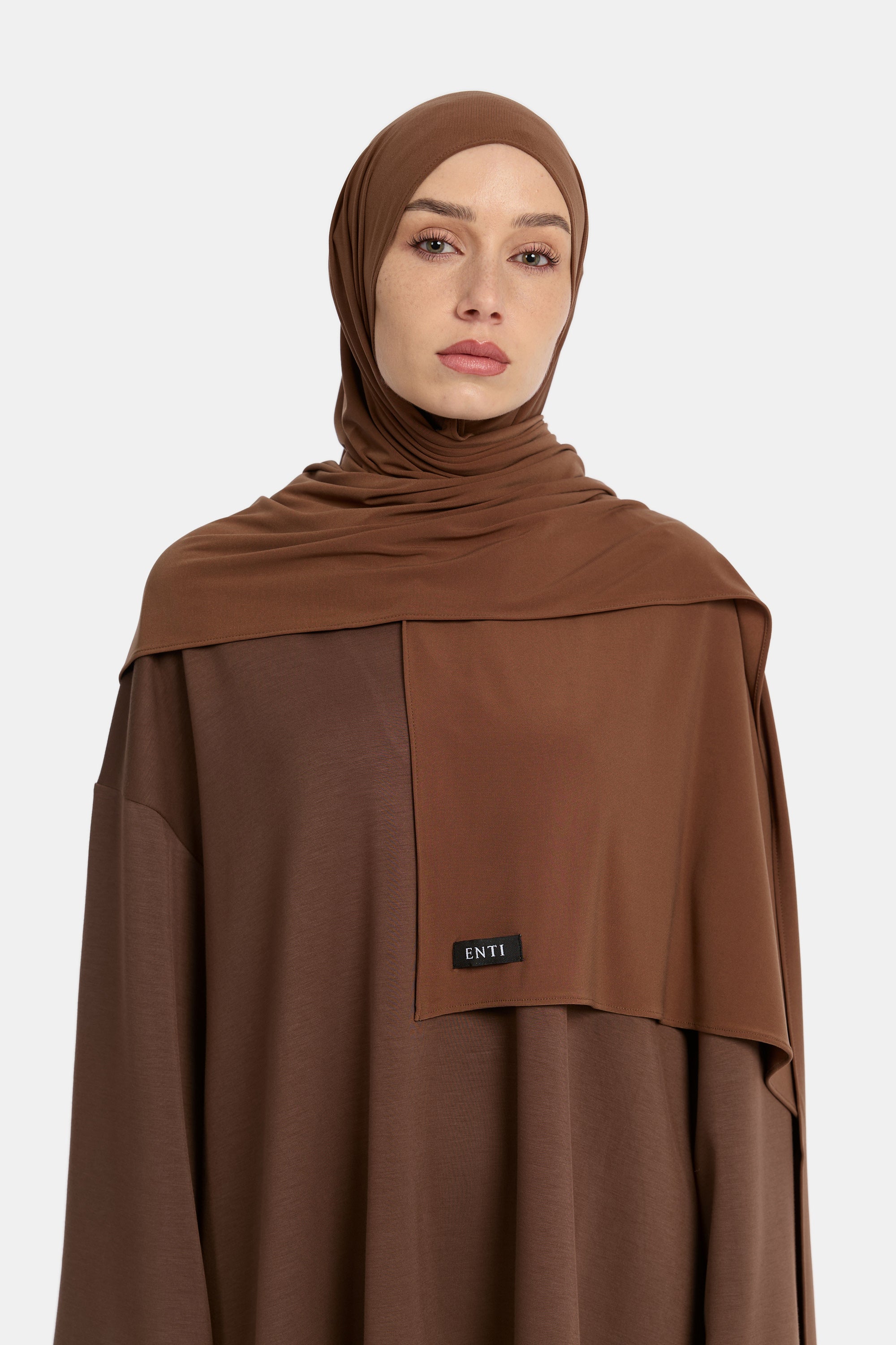 Model draagt de enti premium jersey hoofddoek die ademend is en in de kleur Cinnamon