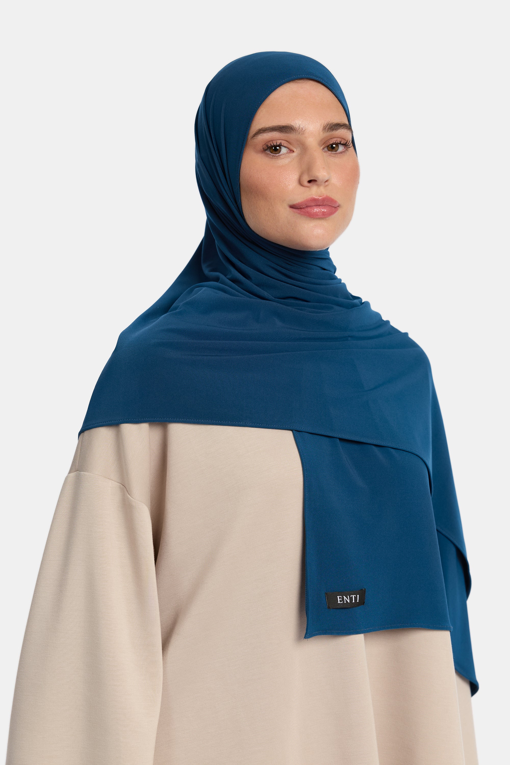 Model draagt de enti premium jersey hoofddoek die ademend is en in de kleur blauw