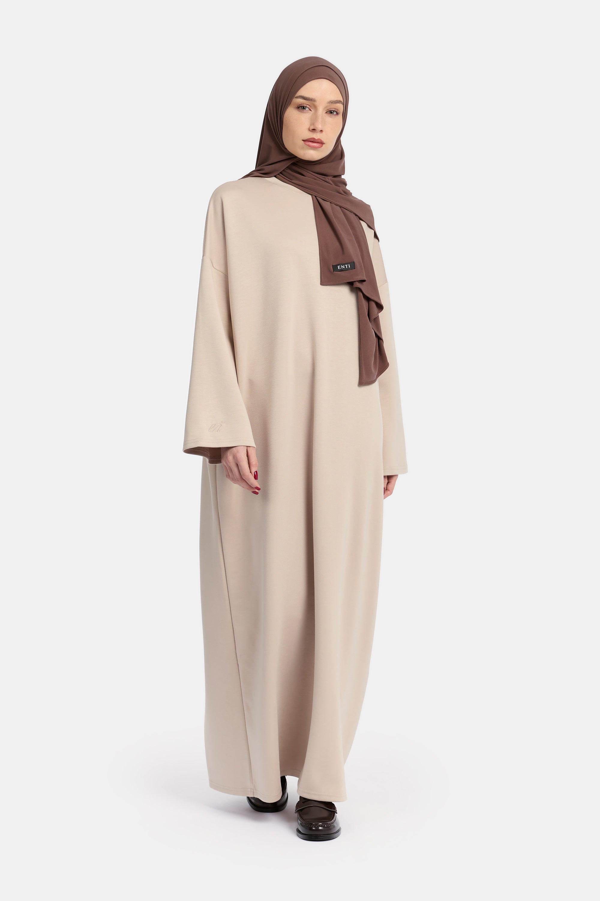 voor aanzicht van model die draagt Wide Sleeve Dress van het modest merk ENTI in de kleur beige
