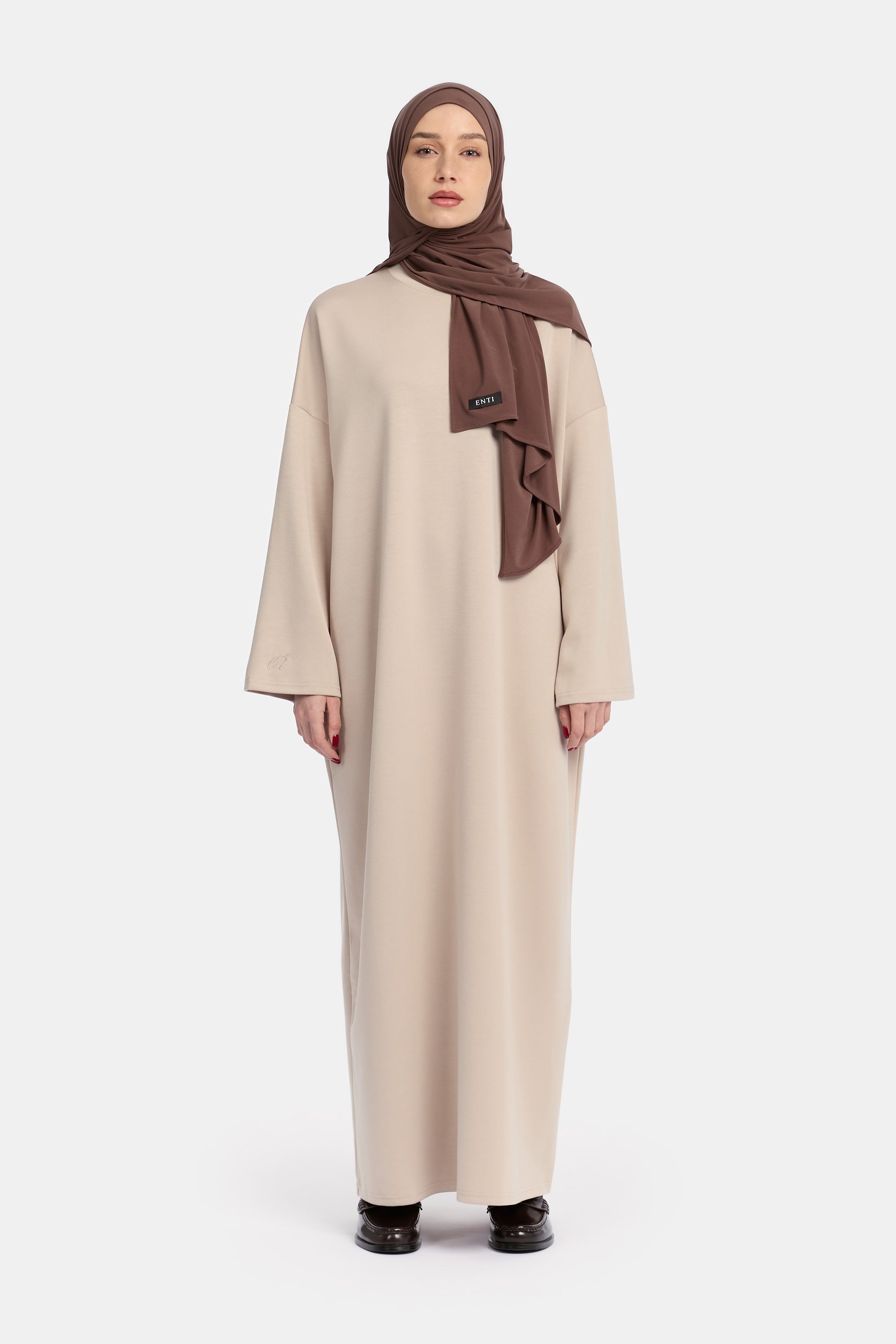 voor aanzicht van model die draagt Wide Sleeve Dress van het modest merk ENTI in de kleur beige